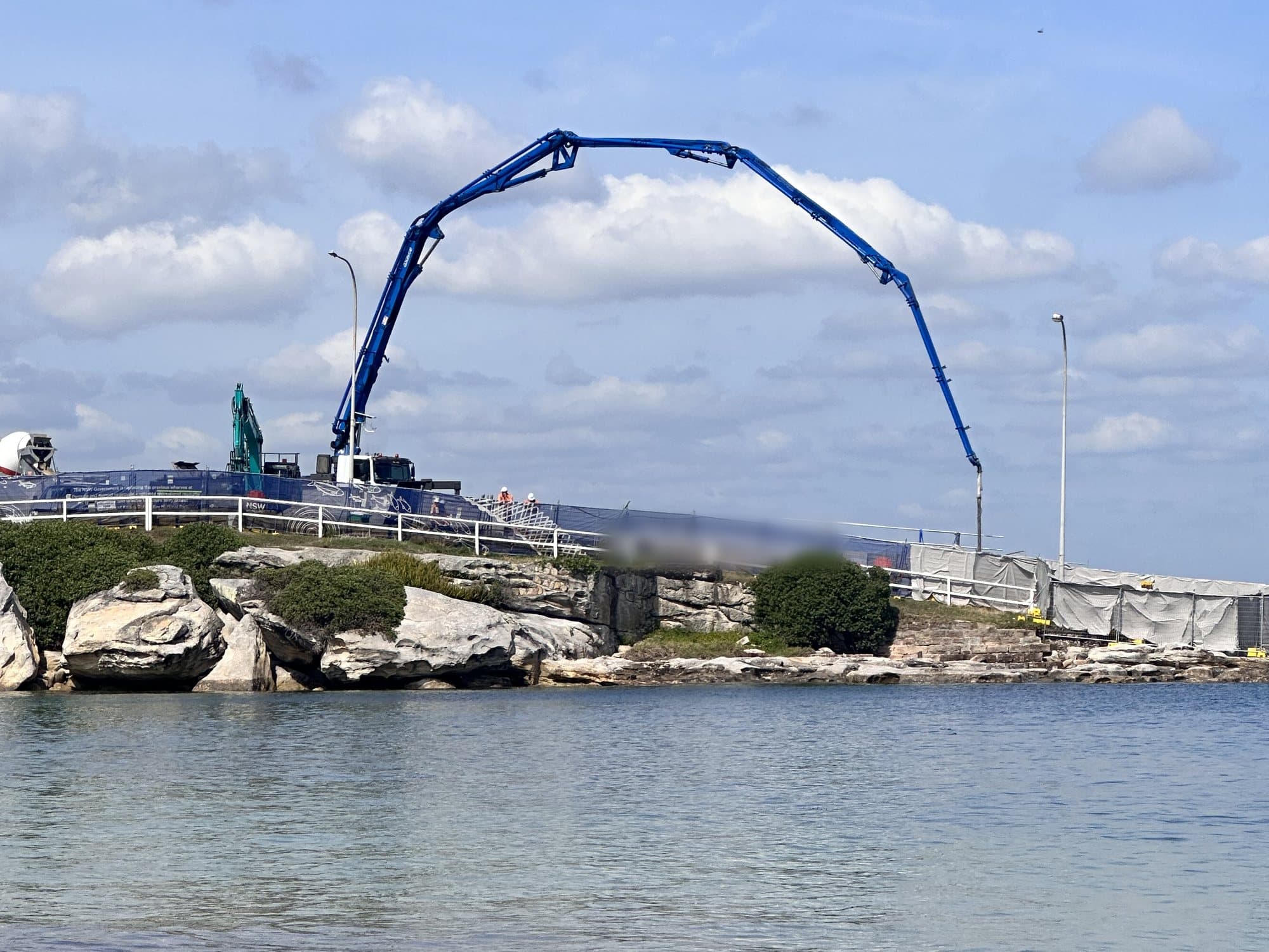 Boom placing concrete on a harbourside seawall