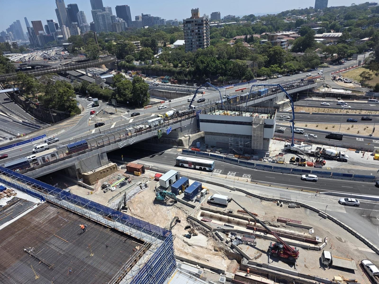 Booms on a freeway job with the Sydney skyline behind